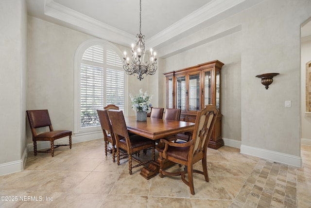 dining area with baseboards, a tray ceiling, and crown molding