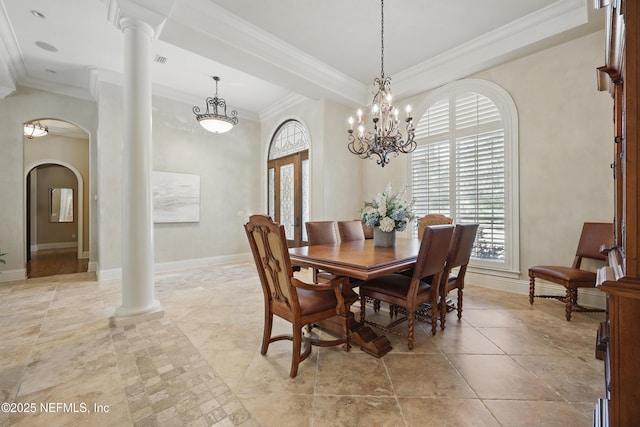 dining area with decorative columns, arched walkways, baseboards, and ornamental molding