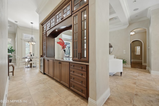 corridor with arched walkways, ornamental molding, wine cooler, and baseboards