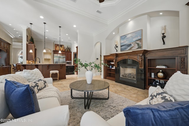 living room featuring recessed lighting, visible vents, ornamental molding, and a glass covered fireplace