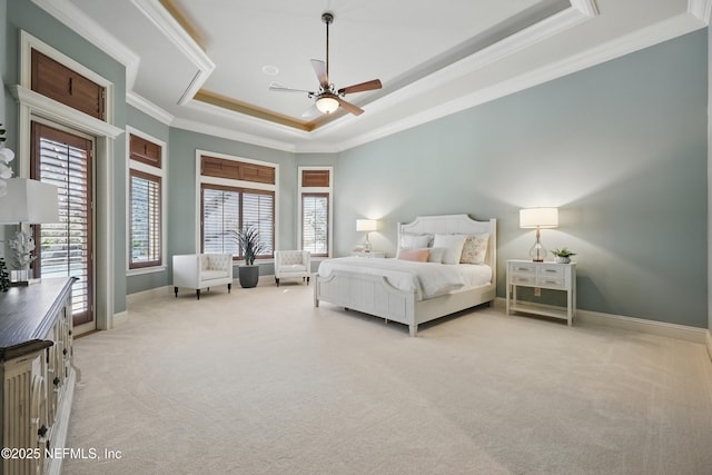 bedroom with carpet, multiple windows, a tray ceiling, and crown molding