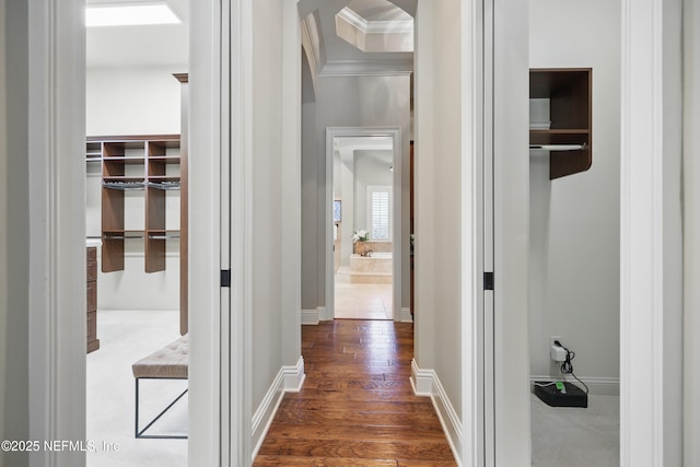 corridor featuring ornamental molding, dark wood-style flooring, and baseboards