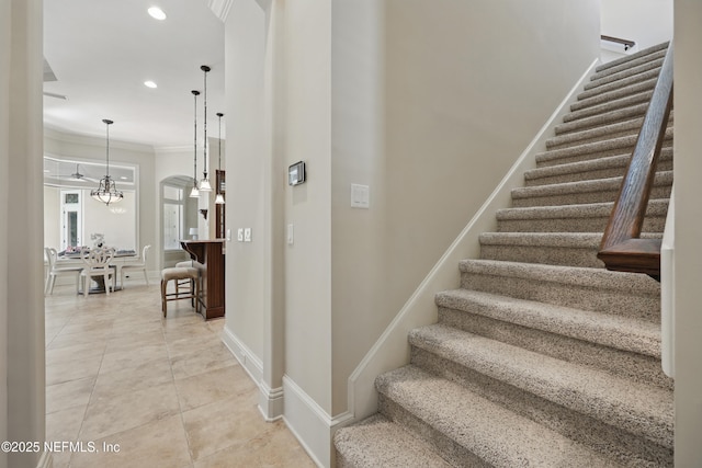 staircase featuring tile patterned flooring, baseboards, crown molding, and recessed lighting