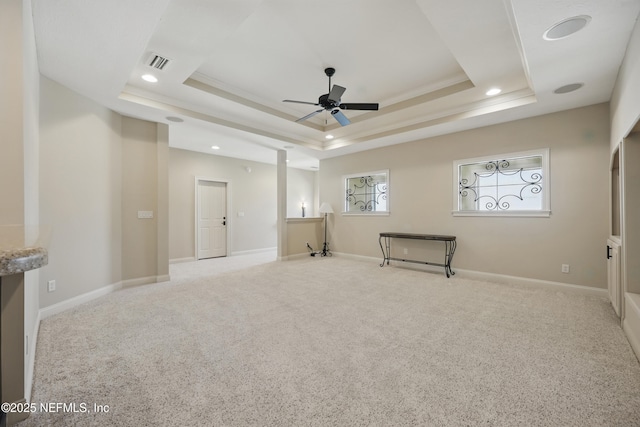 unfurnished room with a ceiling fan, a raised ceiling, visible vents, and baseboards