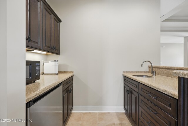 kitchen featuring black microwave, a sink, dark brown cabinetry, and baseboards