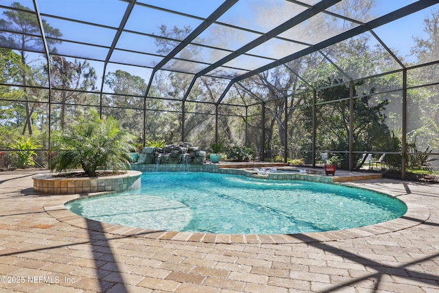 view of pool with glass enclosure, a pool with connected hot tub, and a patio