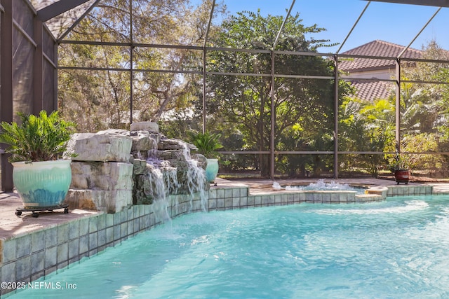 view of pool with glass enclosure and a pool with connected hot tub