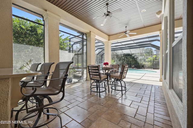 sunroom featuring ceiling fan