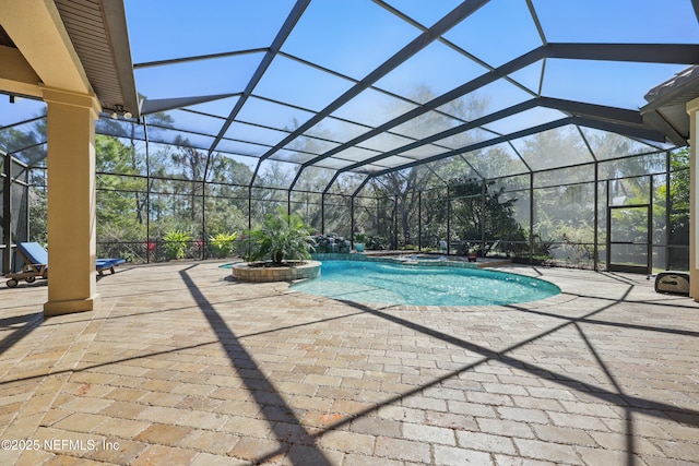 view of pool with a lanai, a patio area, and a pool with connected hot tub