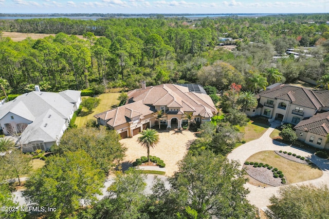 birds eye view of property featuring a forest view