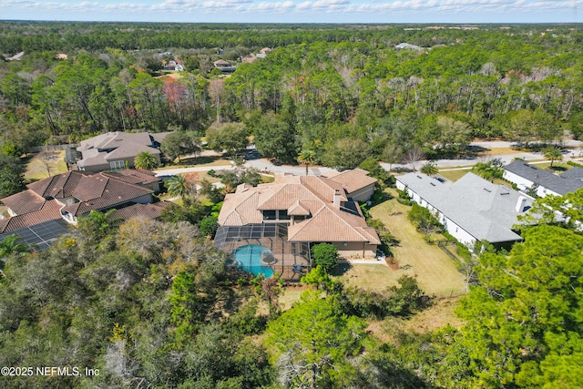 drone / aerial view featuring a residential view and a wooded view