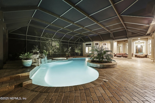 view of swimming pool featuring glass enclosure, a patio, and a pool with connected hot tub