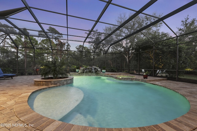 view of pool with glass enclosure, a pool with connected hot tub, and a patio