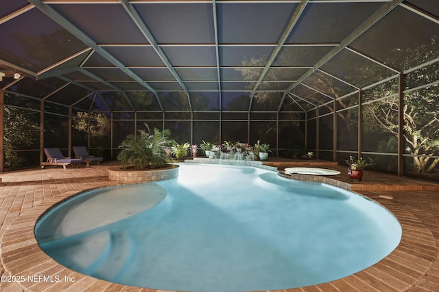 view of swimming pool with glass enclosure, a patio area, and a pool with connected hot tub