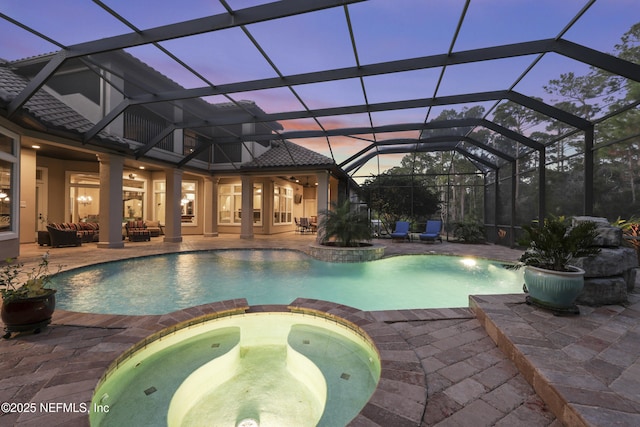 pool at dusk with a pool with connected hot tub, an outdoor living space, and a patio