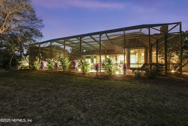 yard at dusk featuring a lanai