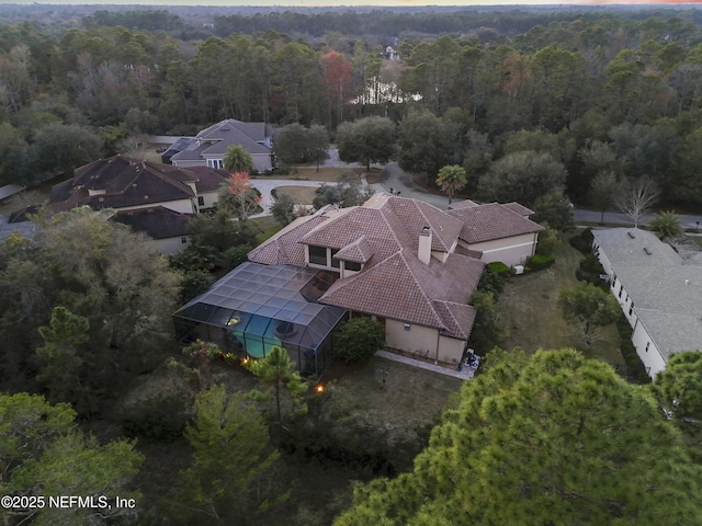 birds eye view of property featuring a view of trees