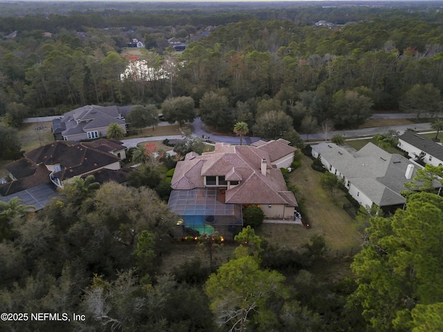 birds eye view of property featuring a wooded view