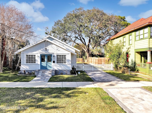 view of front of house featuring entry steps, fence, and a front yard