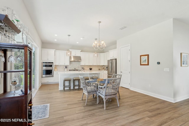 dining area with a notable chandelier, recessed lighting, visible vents, light wood-style floors, and baseboards