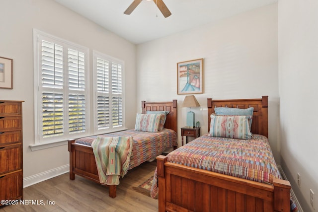 bedroom with light wood finished floors, a ceiling fan, and baseboards