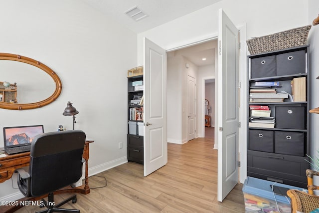 office space featuring light wood-style flooring, visible vents, and baseboards