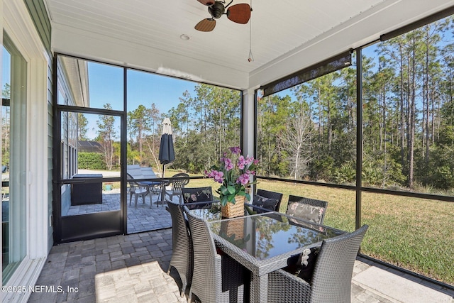 sunroom / solarium featuring a ceiling fan