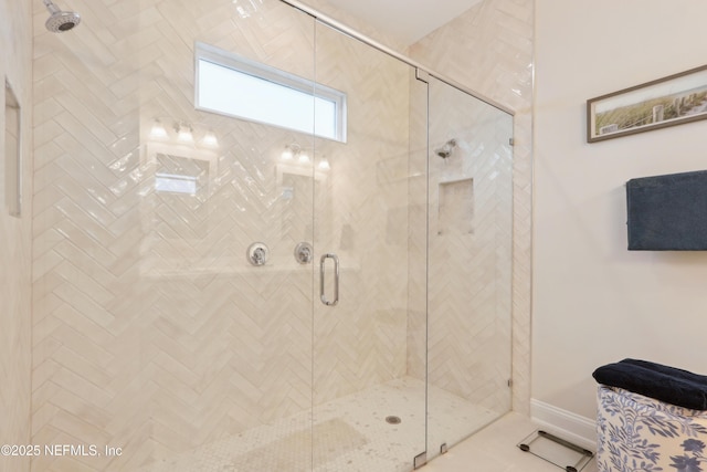 bathroom with a shower stall and baseboards