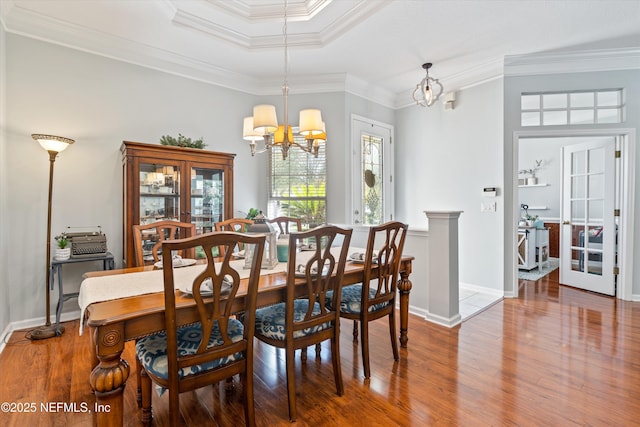 dining area with a notable chandelier, wood finished floors, baseboards, french doors, and ornamental molding