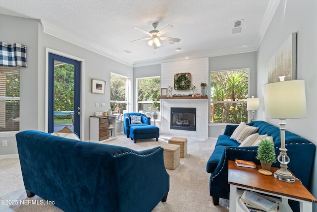 living area featuring ornamental molding, plenty of natural light, and visible vents