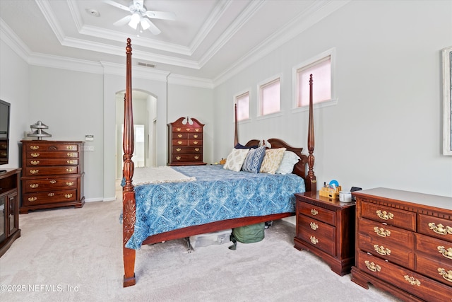 bedroom with visible vents, arched walkways, a raised ceiling, light colored carpet, and crown molding