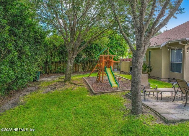 view of yard featuring a playground, fence, and a patio