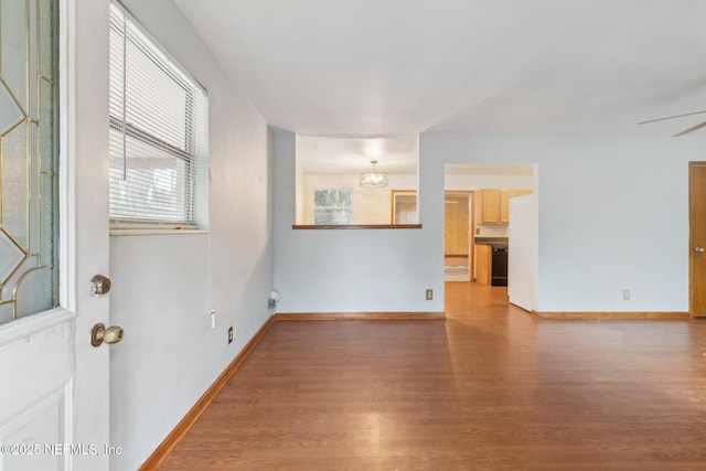 empty room featuring ceiling fan, wood finished floors, and baseboards