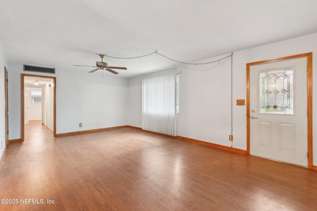 interior space featuring a wealth of natural light, visible vents, baseboards, and wood finished floors