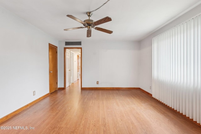 unfurnished room with ceiling fan, light wood-style flooring, visible vents, and baseboards