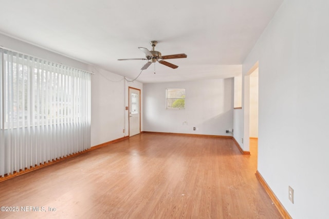 spare room featuring light wood-style flooring, baseboards, and ceiling fan