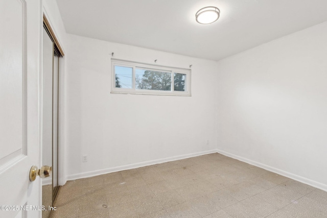 unfurnished bedroom featuring light floors, baseboards, and a closet