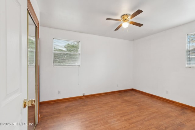 spare room featuring ceiling fan, baseboards, and wood finished floors