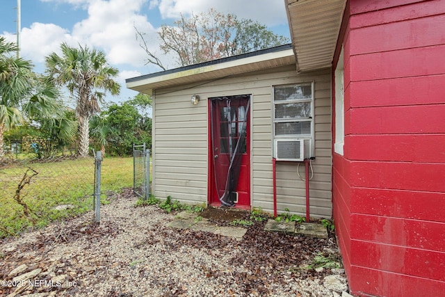 view of outbuilding with fence, cooling unit, and an outbuilding