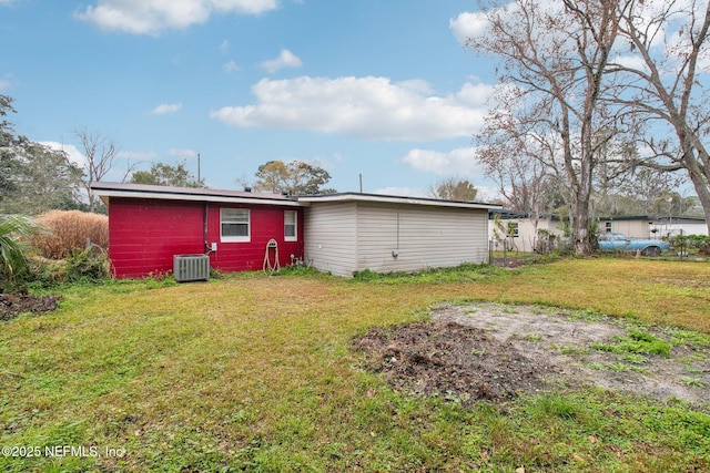 rear view of property featuring central AC and a yard