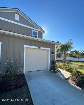 garage with concrete driveway and central AC