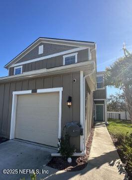 view of side of property with driveway and an attached garage