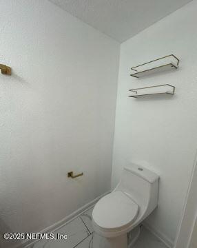 bathroom with toilet and baseboards