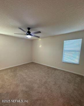 carpeted empty room featuring a textured ceiling, a ceiling fan, and baseboards