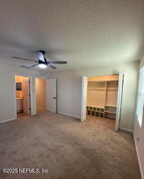 unfurnished bedroom featuring carpet, ceiling fan, a textured ceiling, and baseboards