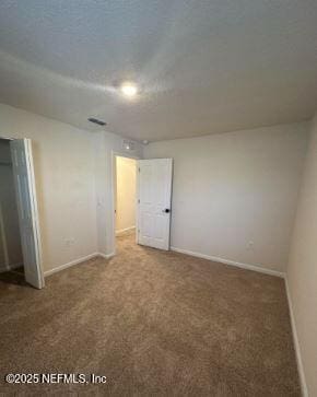 unfurnished bedroom with carpet floors, a closet, visible vents, and baseboards