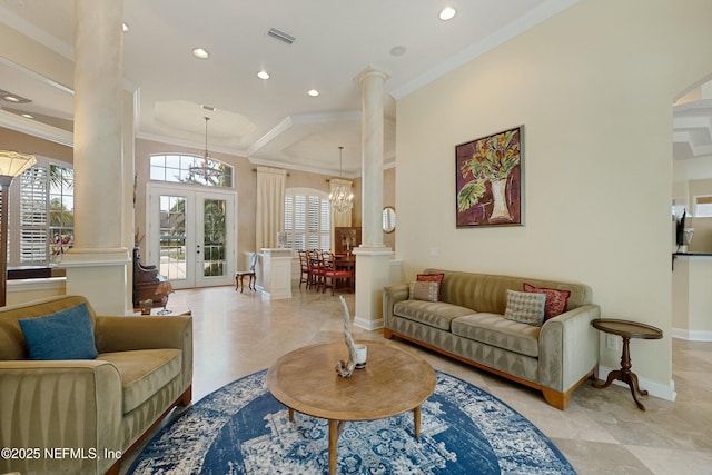 living area featuring crown molding, french doors, a notable chandelier, and decorative columns