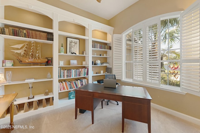 carpeted home office with plenty of natural light and baseboards