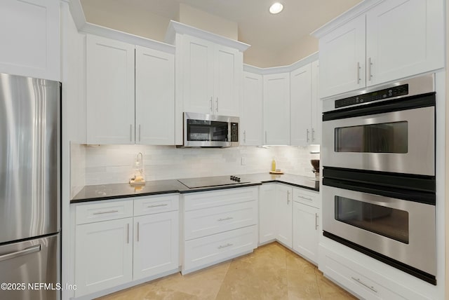 kitchen with white cabinets, dark countertops, appliances with stainless steel finishes, backsplash, and recessed lighting