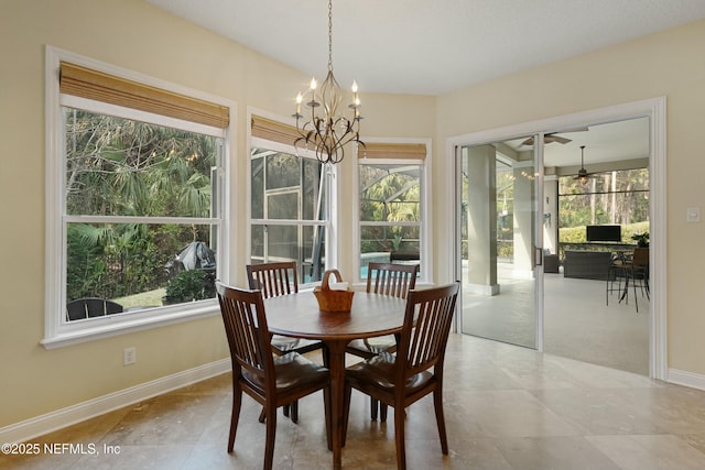 dining area with ceiling fan with notable chandelier and baseboards